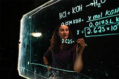 化学学生在玻璃板上写字